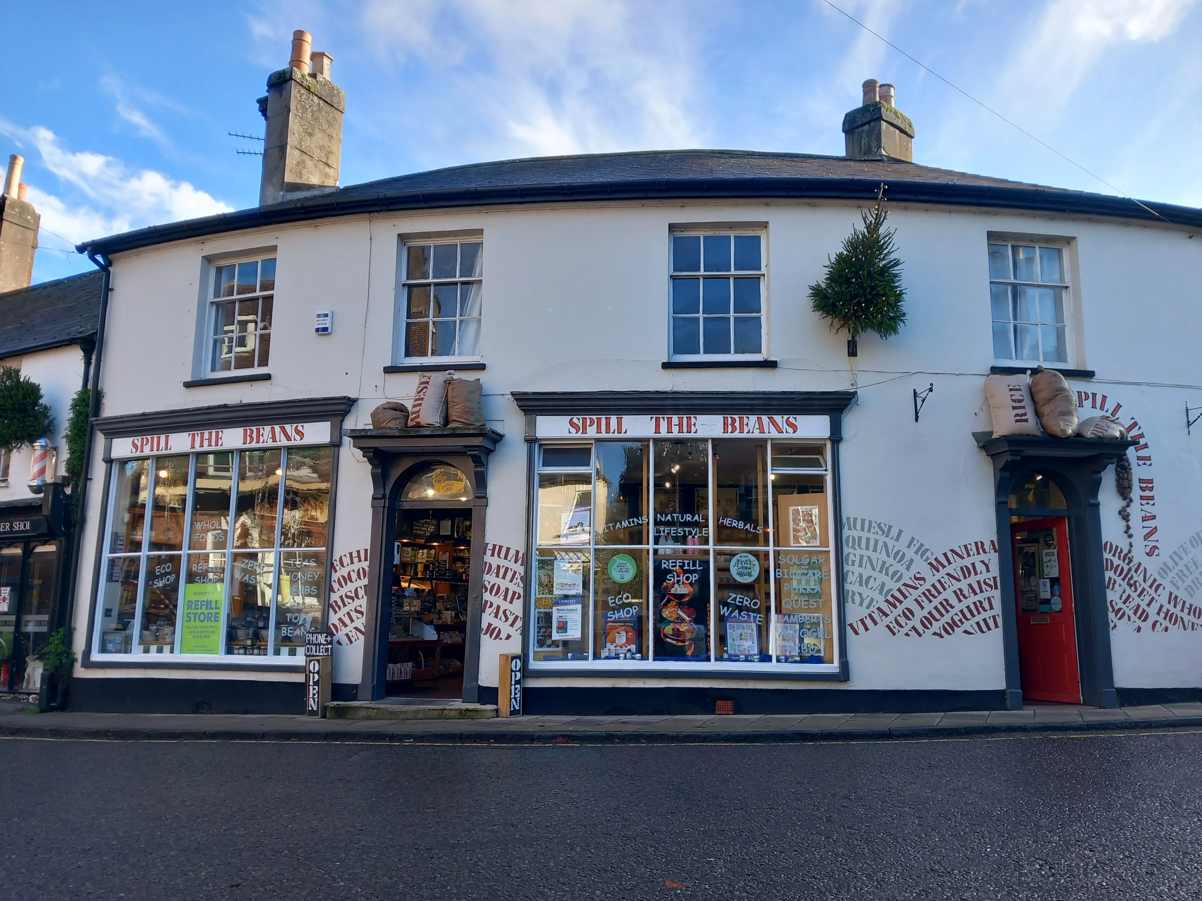The Spill the Beans shopfront on West Street, Wimborne, its walls painted with the names of what is inside